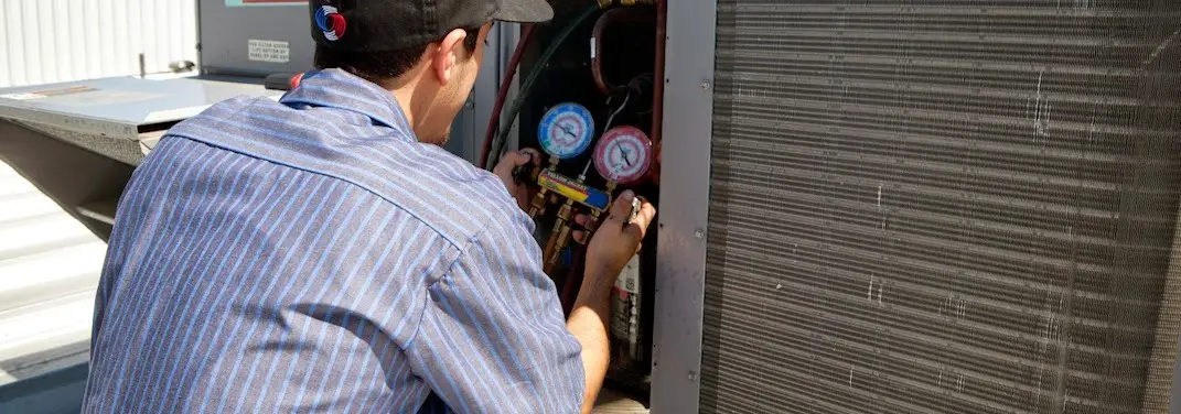 HVAC technician servicing a condenser unit in Hornell
